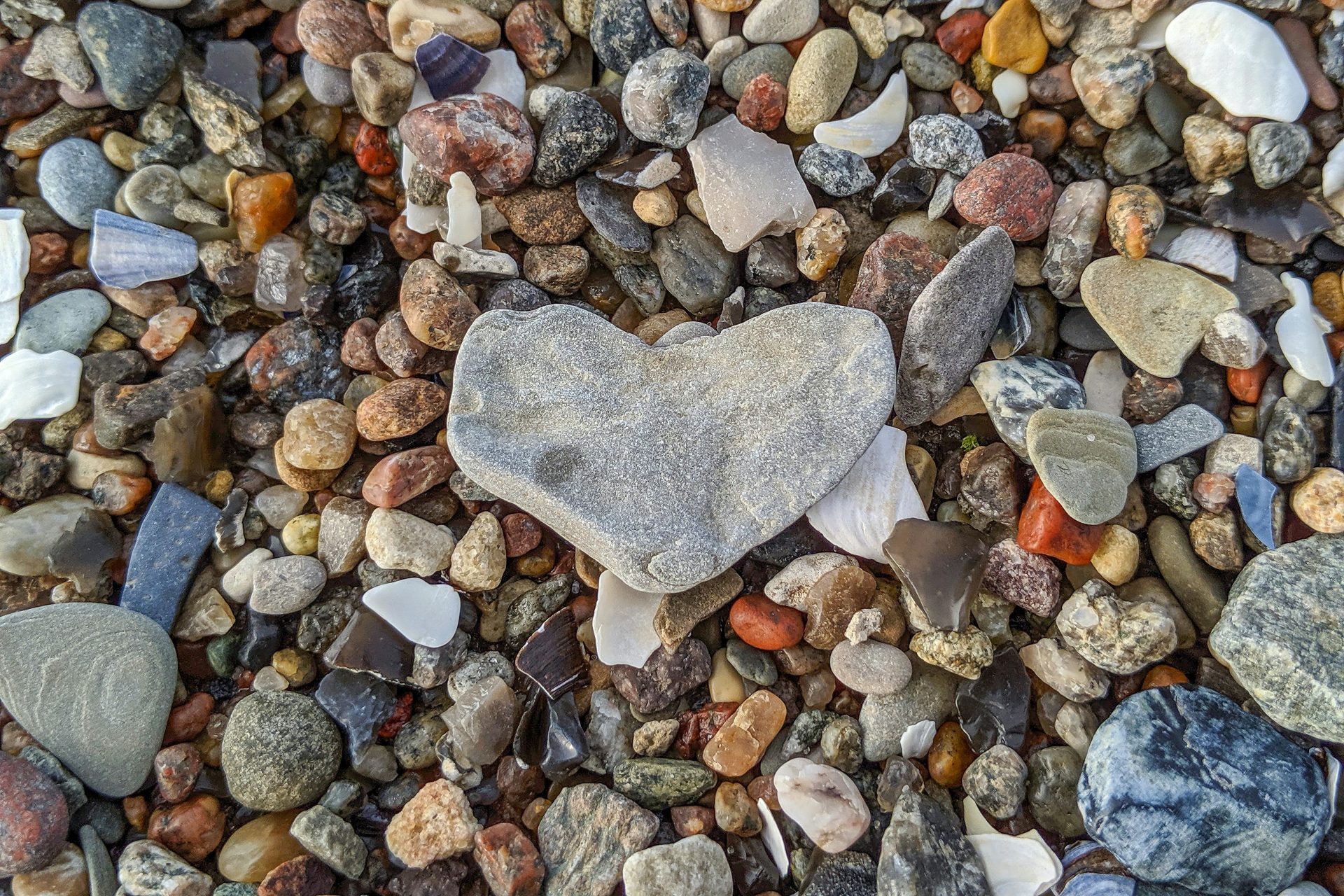 a heart shaped rock sitting on top of a pile of rocks